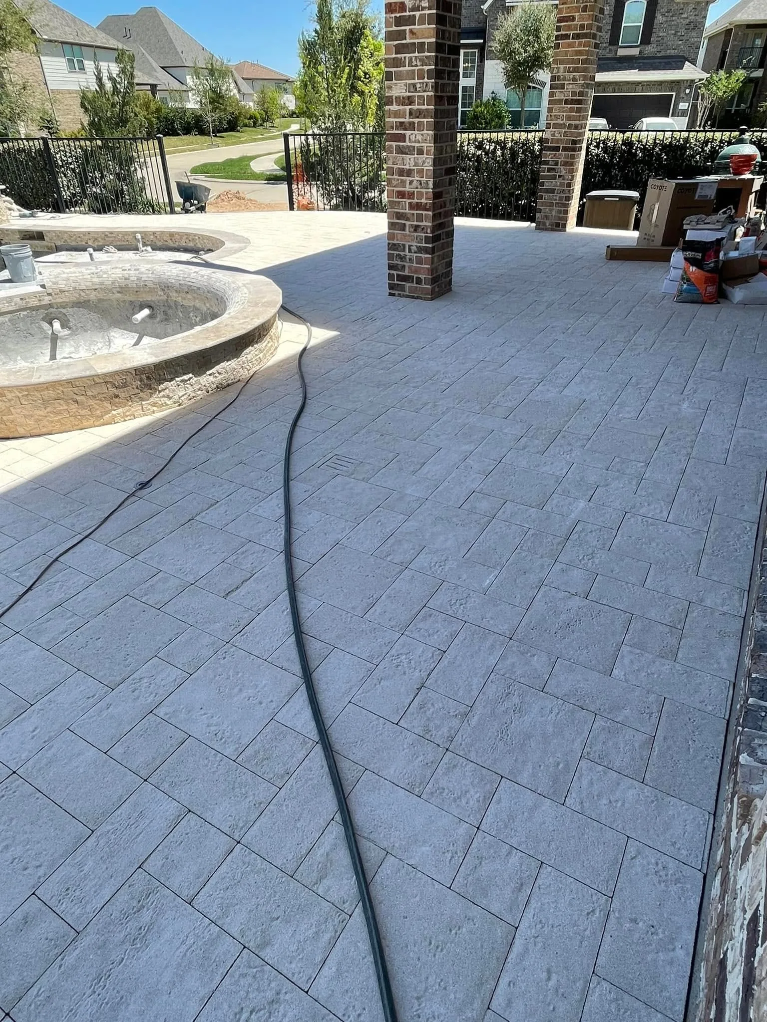 Stone deck and spa beside brick patio columns