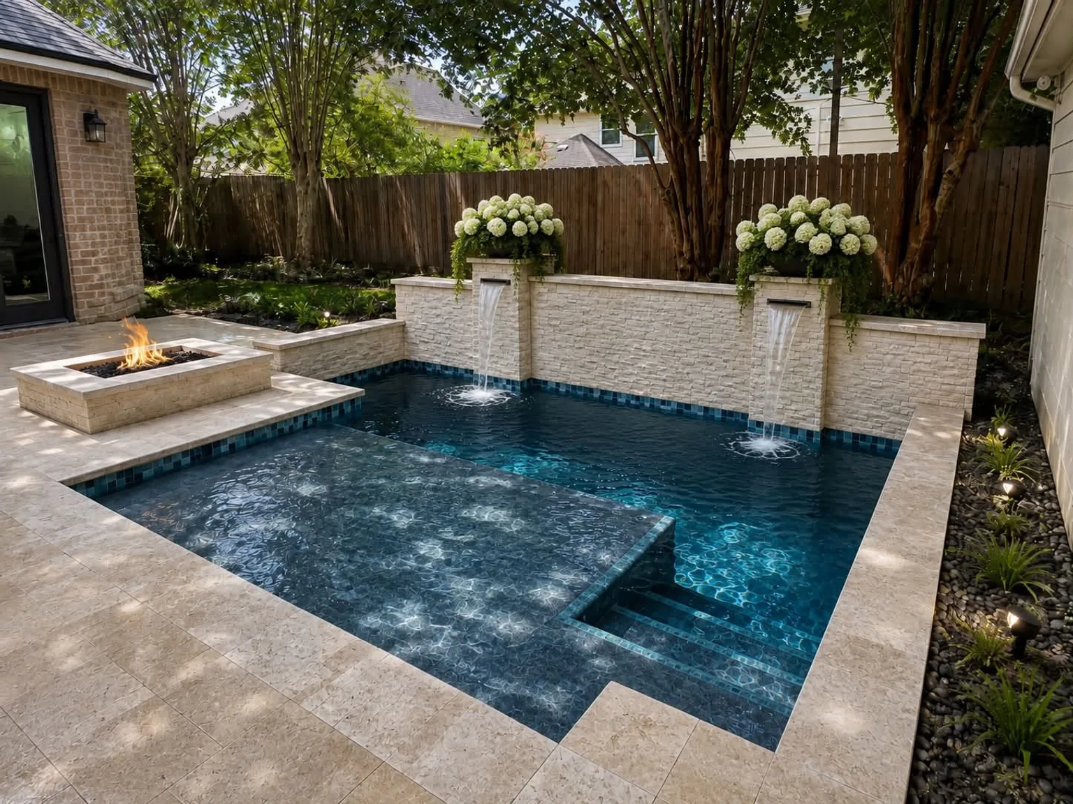 Compact pool with blue tile, pale stone waterfalls, and a brick patio wall