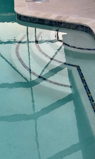Refinished pool steps under water with contrasting dark tile edges
