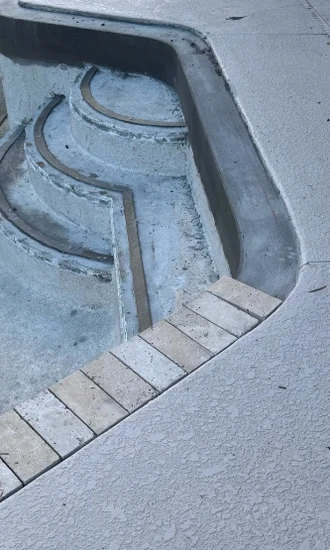 Worn curved entry steps in a drained pool