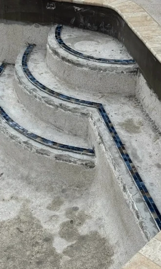 Prepared pool steps with new dark tile markers along the tread edges